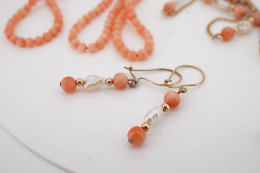 A suite of modern 9ct gold, coral and baroque pearl set jewellery, comprising a necklace, 38cm, a bracelet, 16cm and a pair of drop earrings, together with one other coral bead necklace.